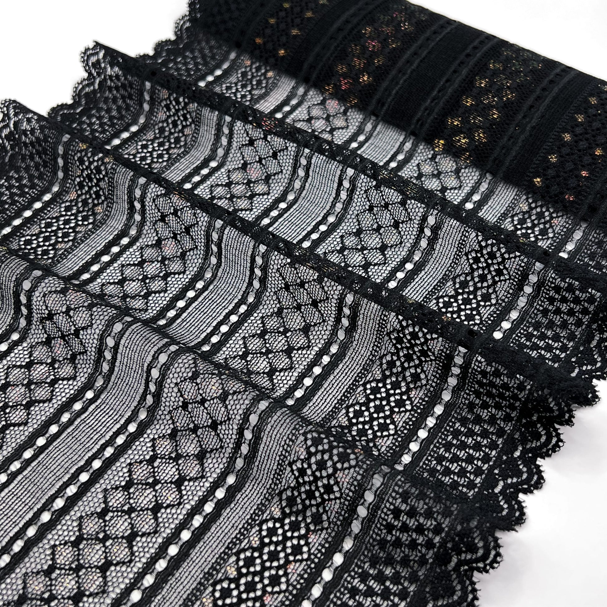 he black elastic lace trim folded in pleats, showcasing its intricate geometric patterns and shimmering lurex highlights.