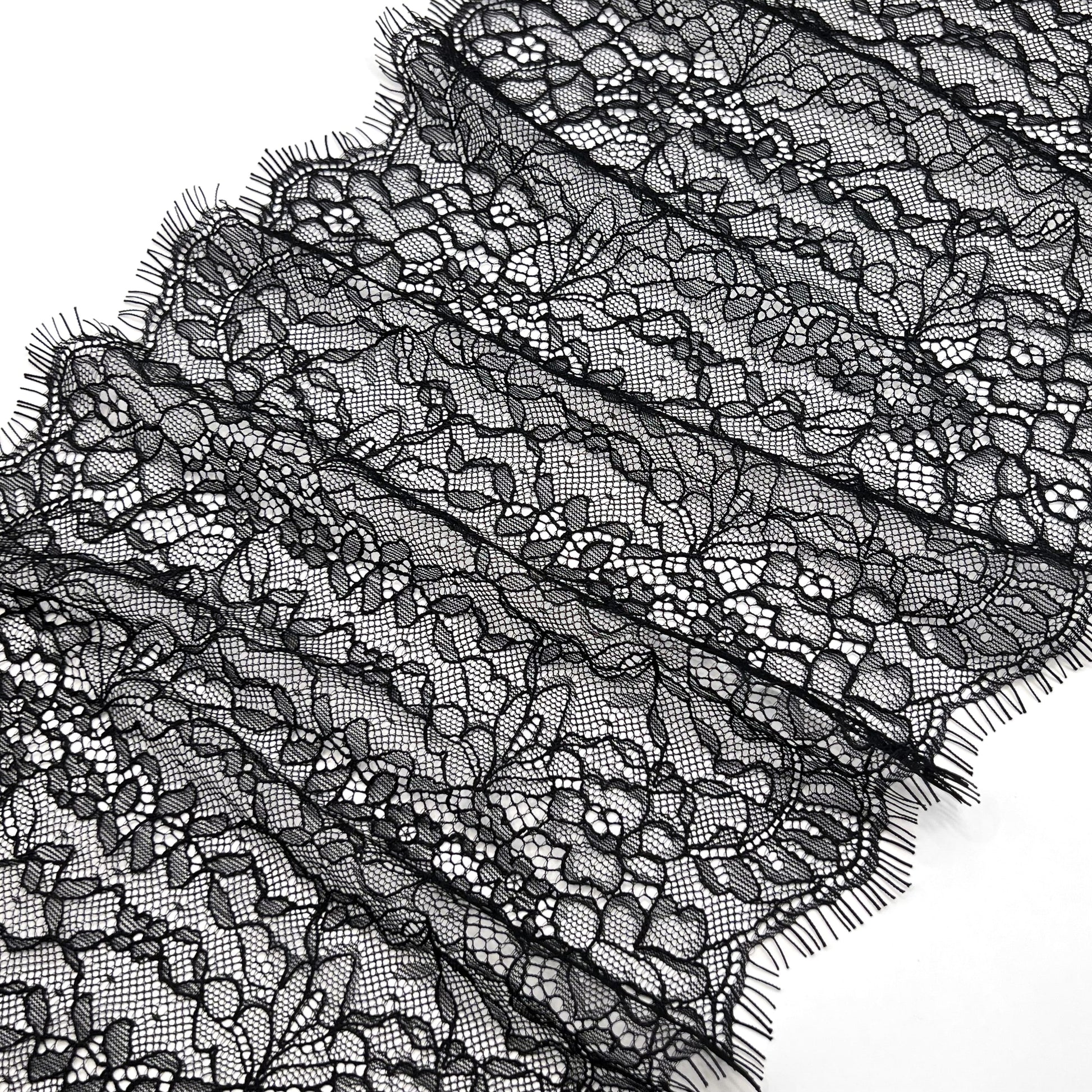 Close-up of 22 cm black Chantilly lace showcasing its delicate floral design, perfect for elegant lingerie and apparel embellishments.