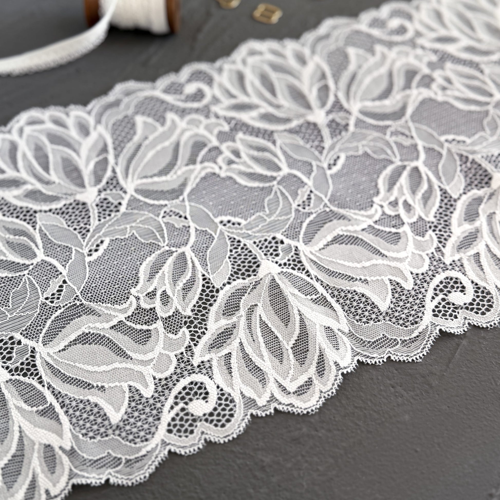Close-up of white stretch lace with intricate floral designs, perfect for creating handmade lingerie and elegant bralettes.