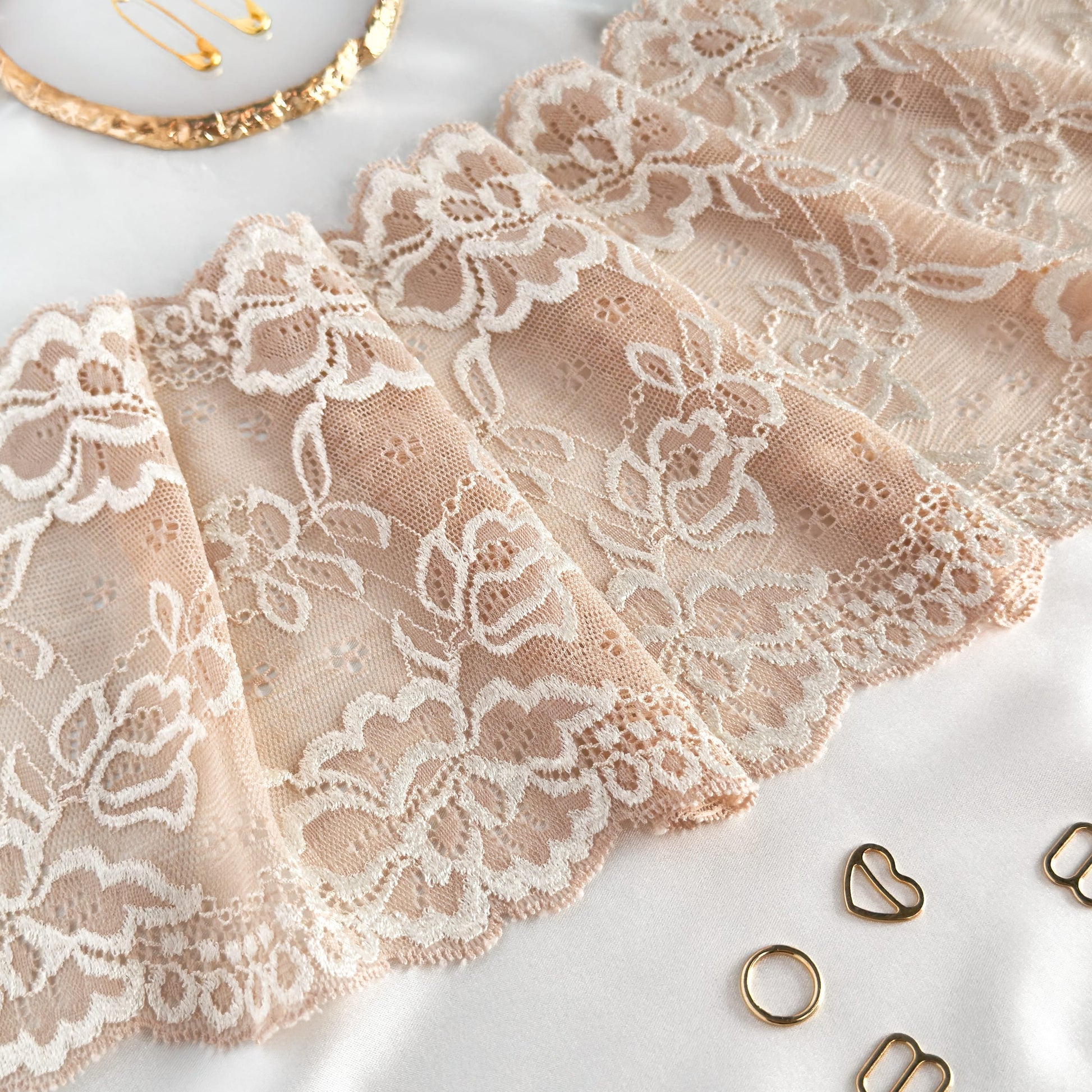 Close-up of cold beige elastic lace, 16cm wide, showcasing detailed floral pattern