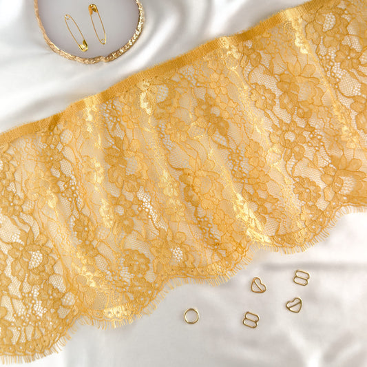 18 cm wide mustard yellow Chantilly lace styled with gold accessories, highlighting its versatile use for lingerie sewing and garment trims.