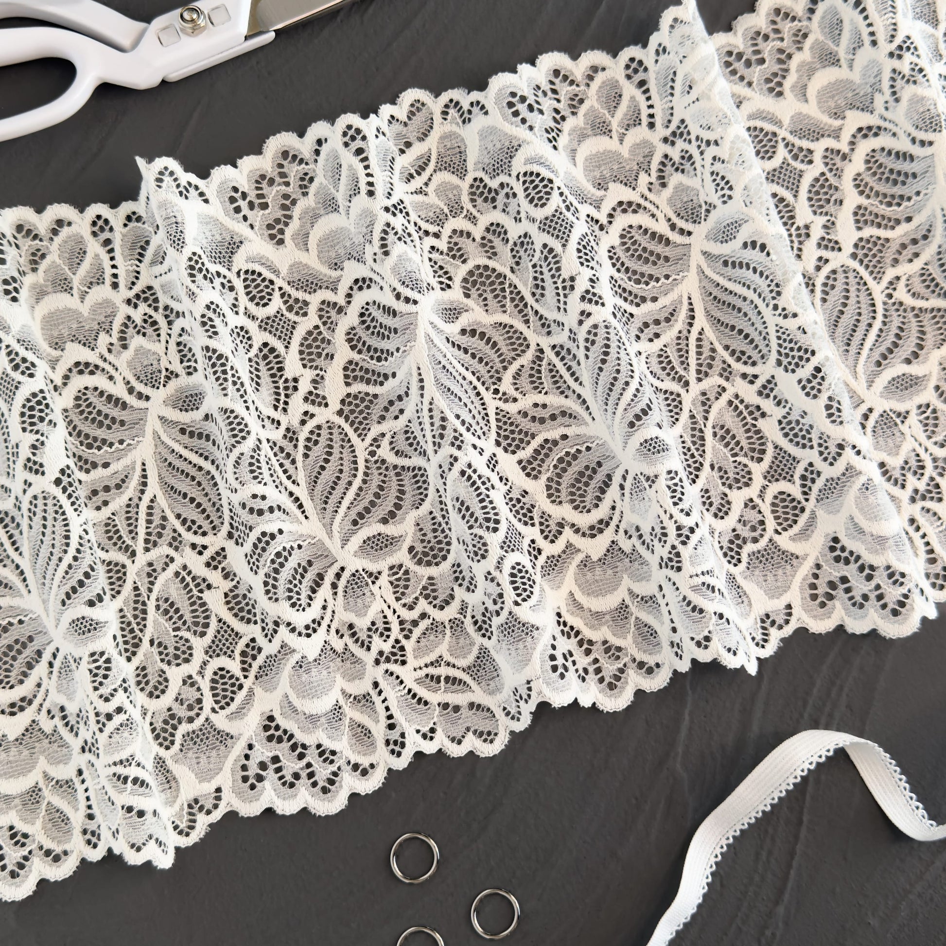 Milk-colored elastic lace trim, 20cm wide, featuring intricate off-white floral patterns, ideal for creating bridal and luxury lingerie.