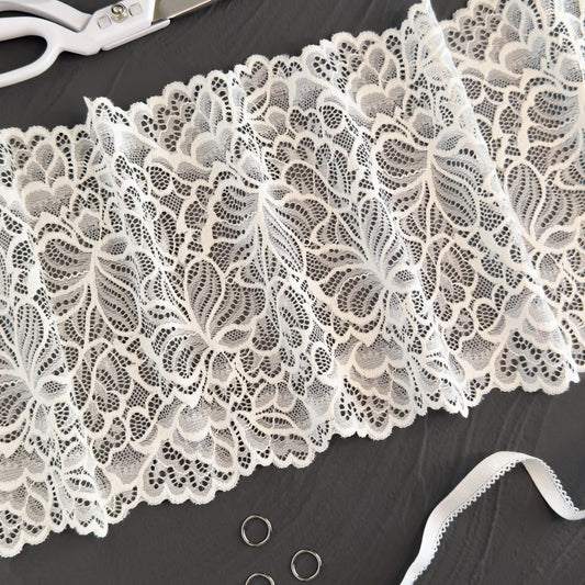 Milk-colored elastic lace trim, 20cm wide, featuring intricate off-white floral patterns, ideal for creating bridal and luxury lingerie.