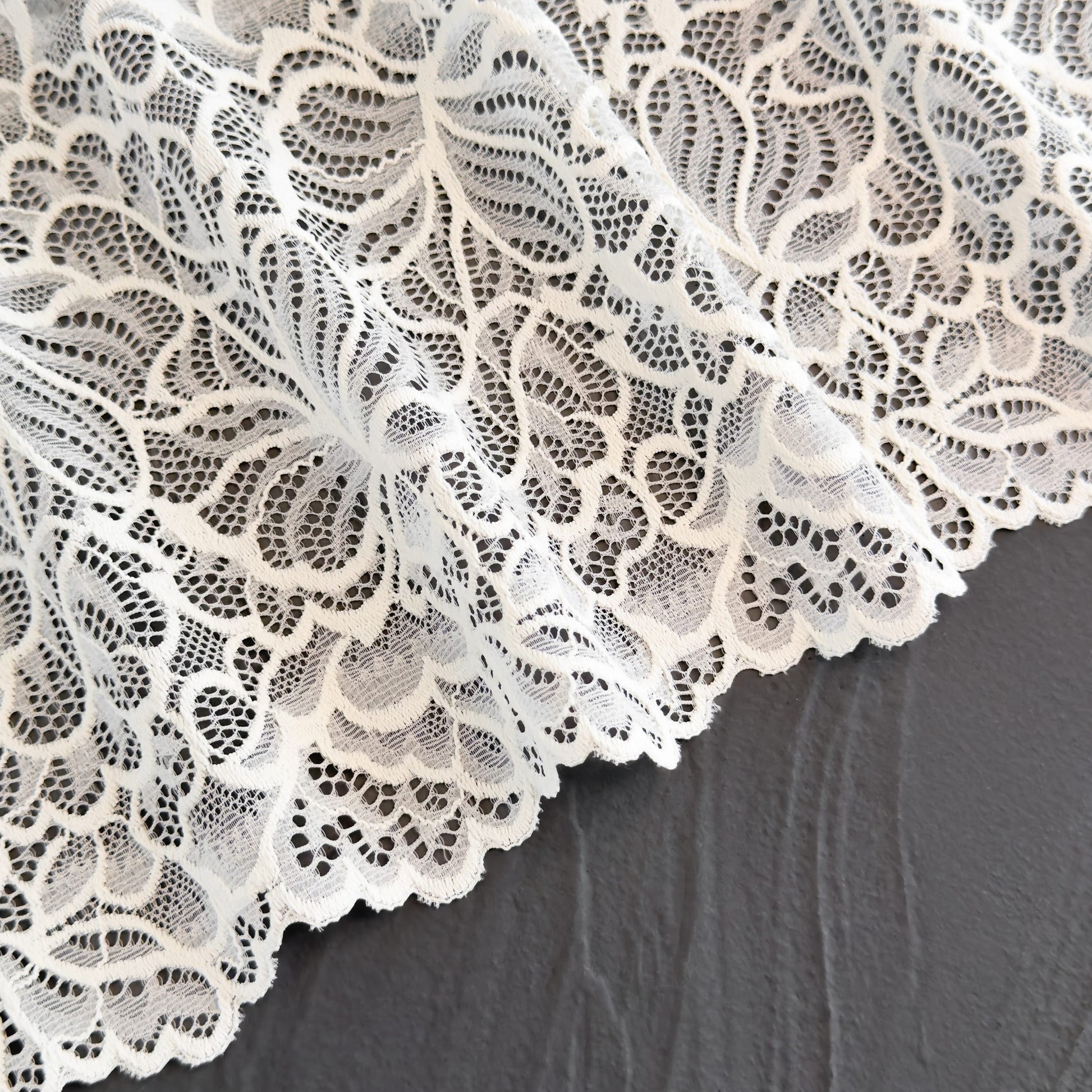 Close-up of off-white stretch lace with a delicate floral design, perfect for handmade lingerie and elegant bralettes.