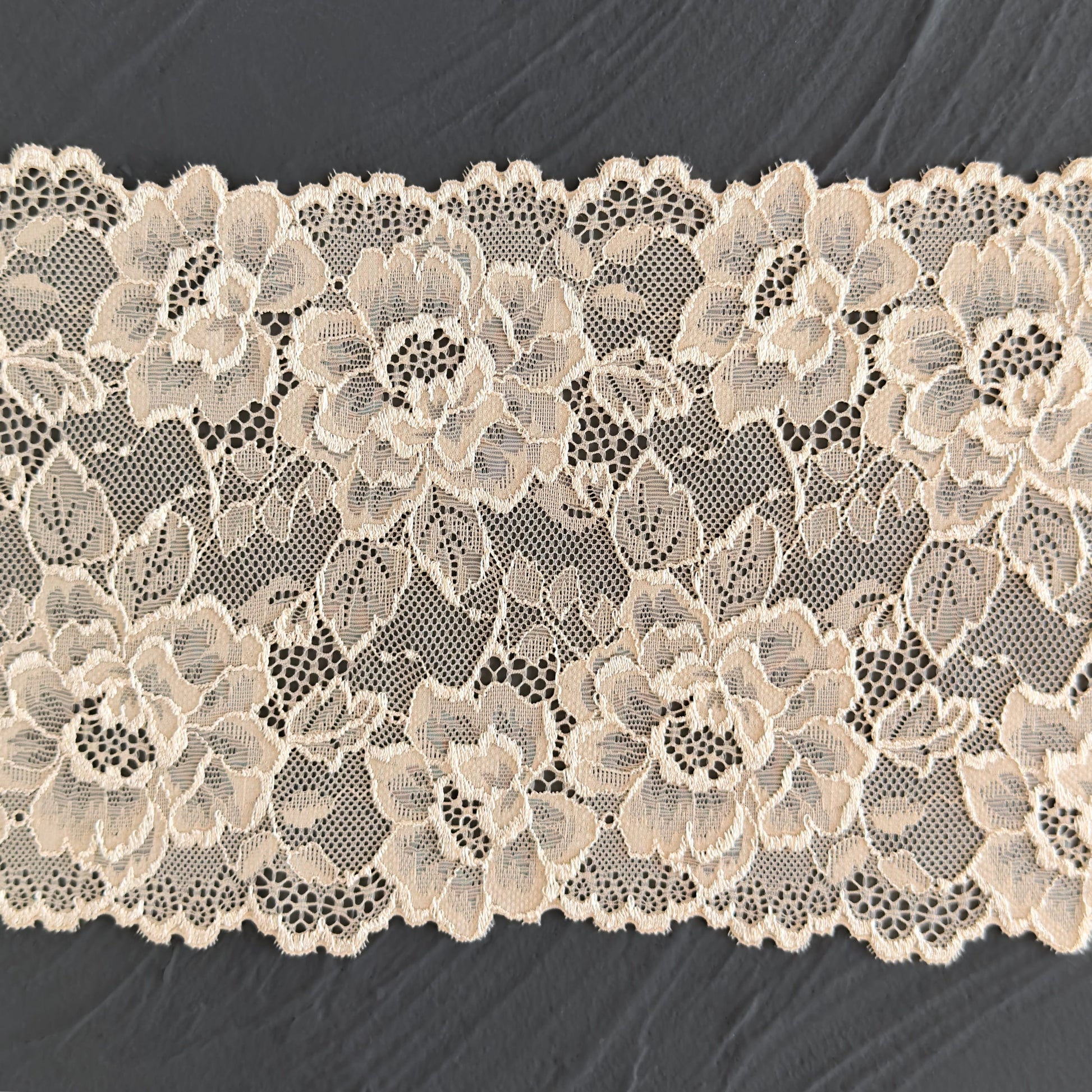 Close-up of beige stretch lace, highlighting delicate floral designs and a soft texture for DIY lingerie projects.