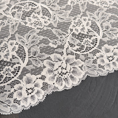 Close-up of white floral lace fabric on a dark background