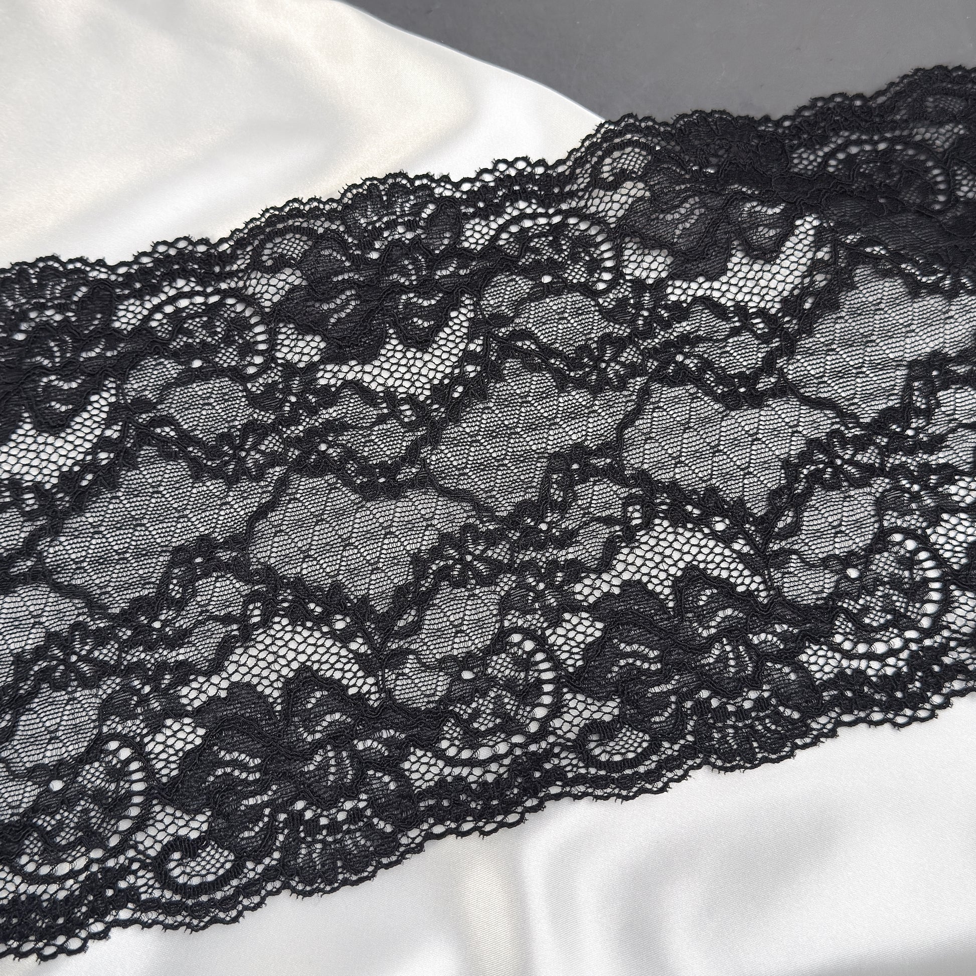 Close-up of black lace fabric on a white background