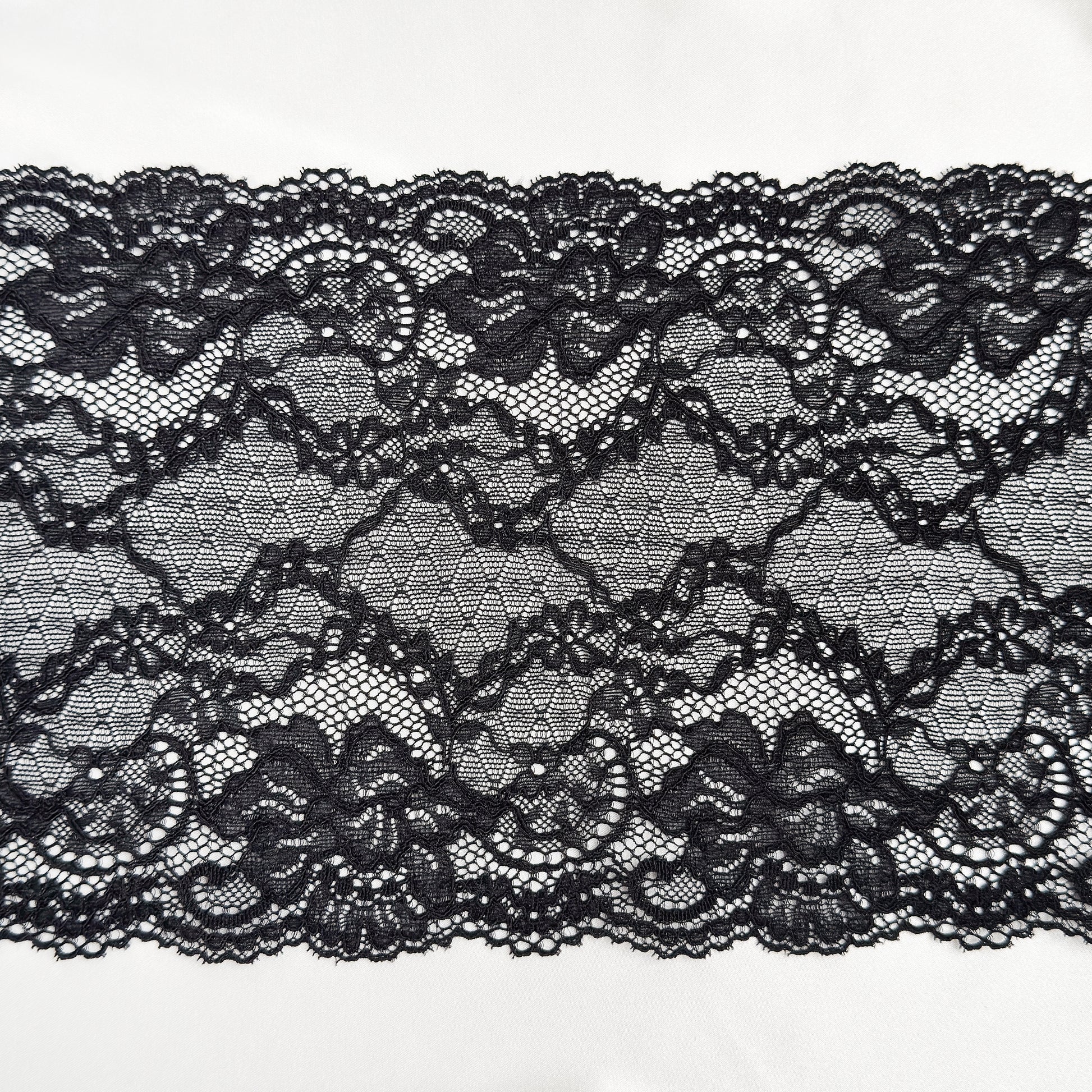 Black lace fabric on a white background