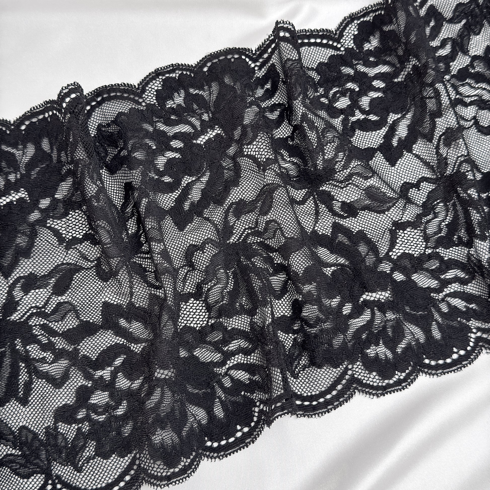 Close-up of black lace fabric on a white background
