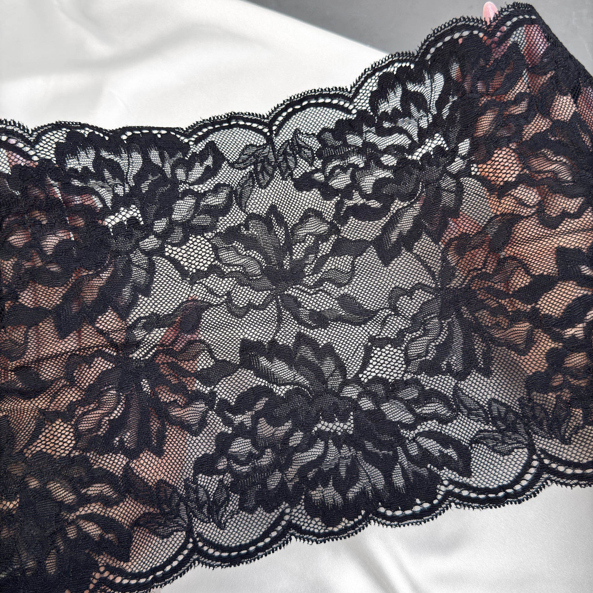 Close-up of black lace fabric on a white background