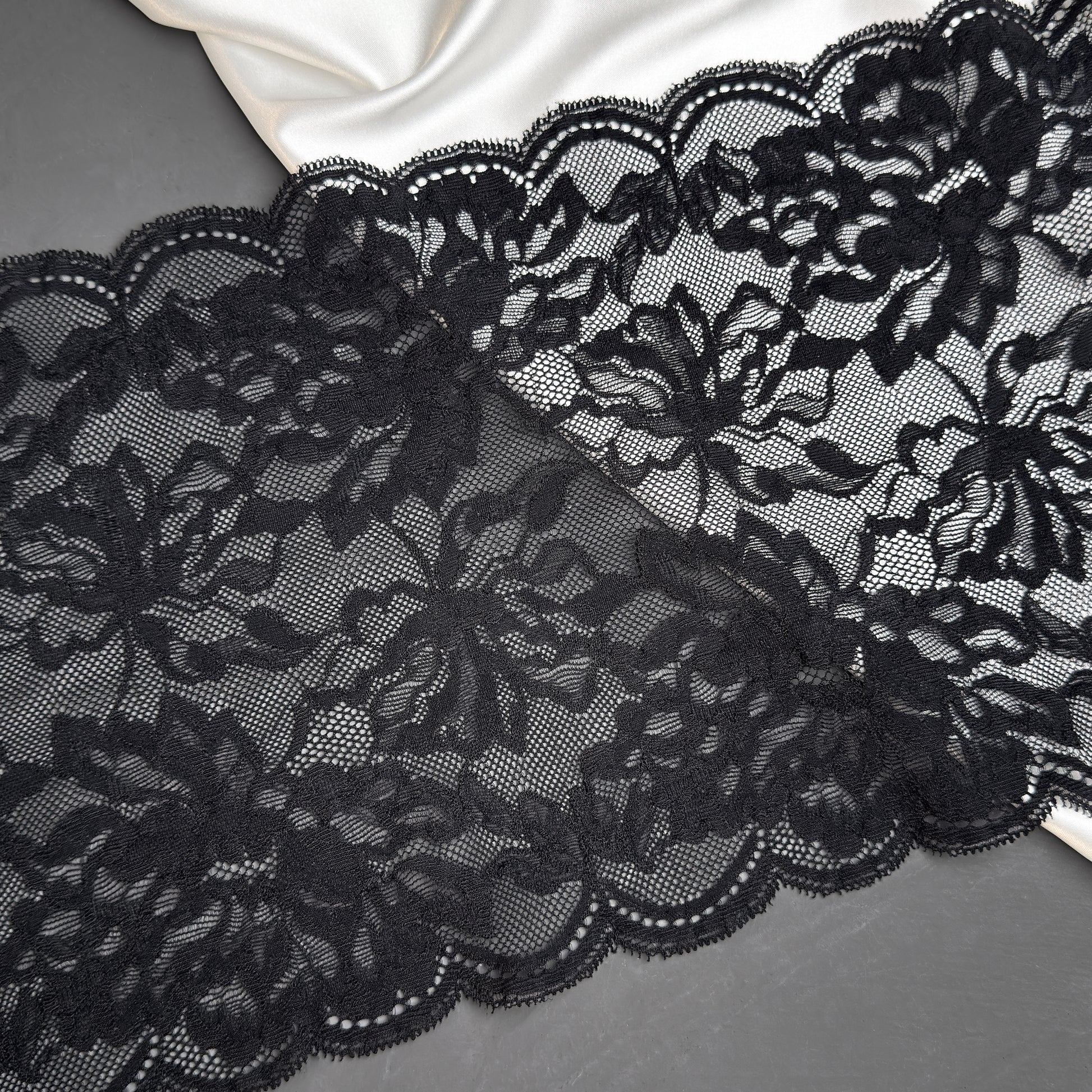 Close-up of black lace fabric on a gray background