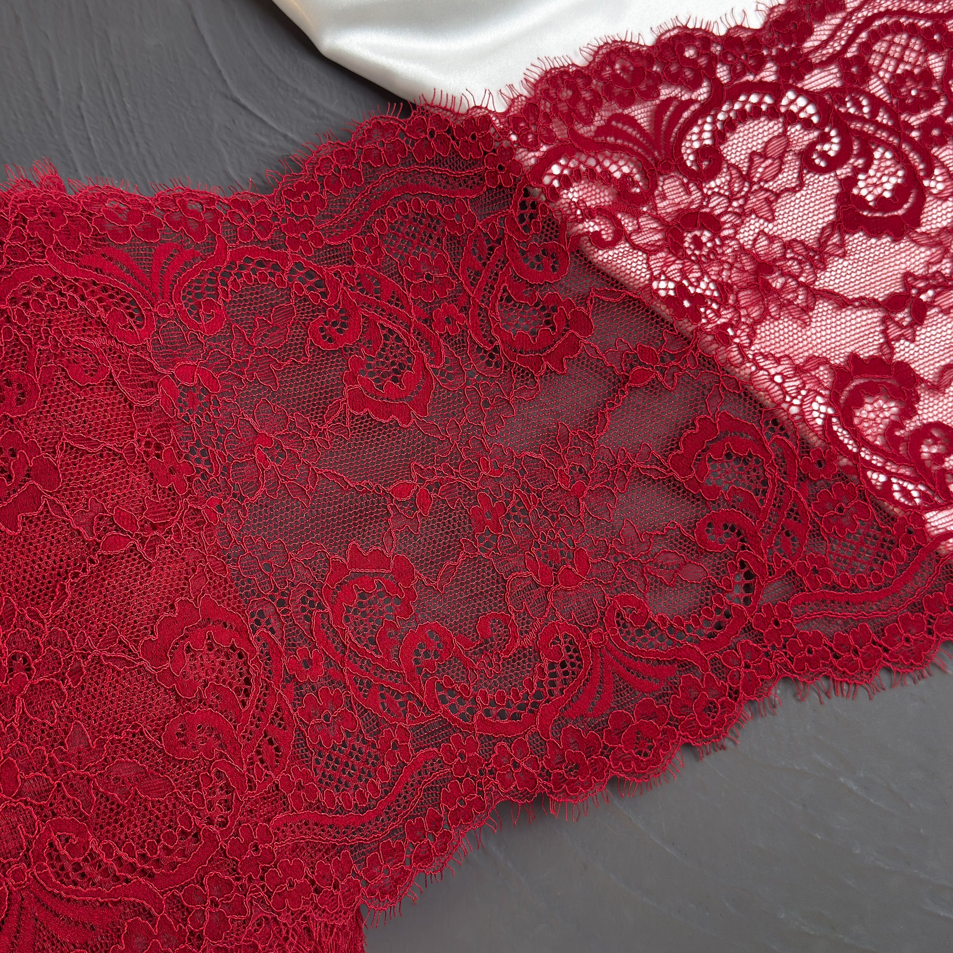 Close-up of red lace fabric on a gray background