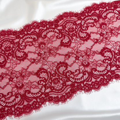 Close-up of dark red lace fabric on a white background
