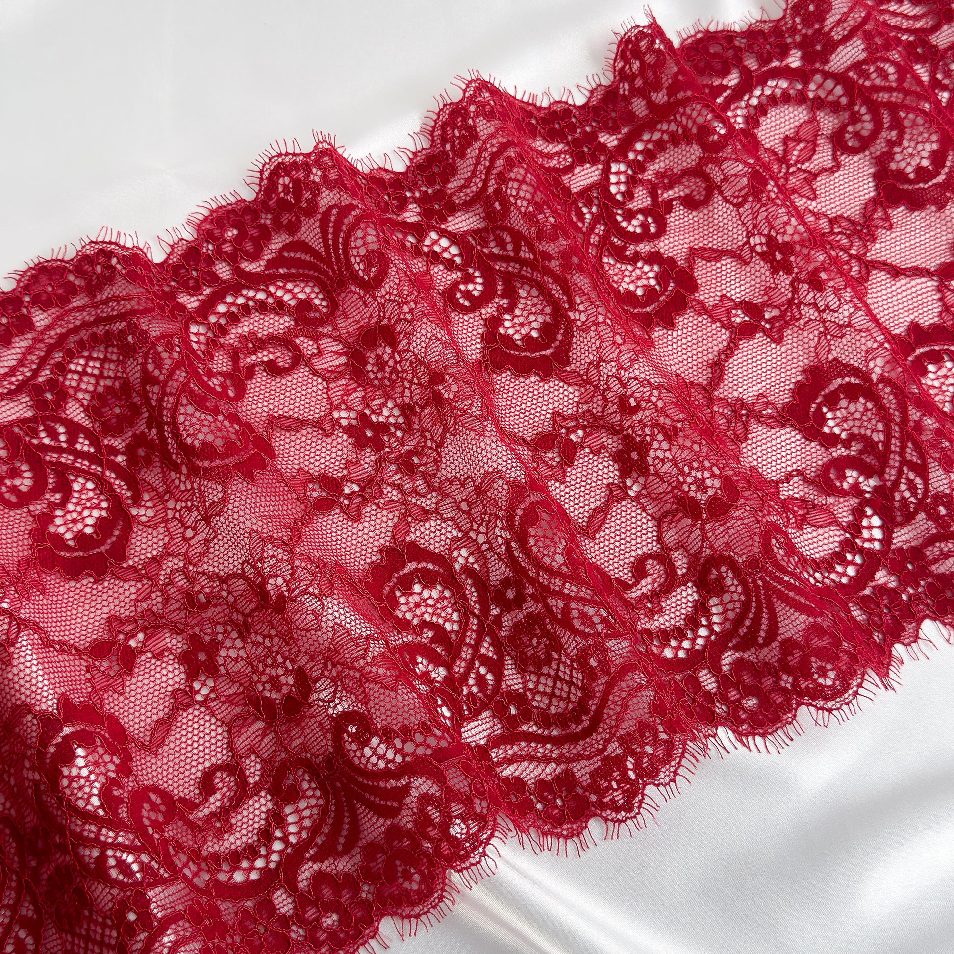 Close-up of red lace fabric on a white background